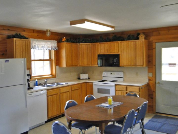 Cozy rustic cabin kitchen with wooden cabinets and dining table